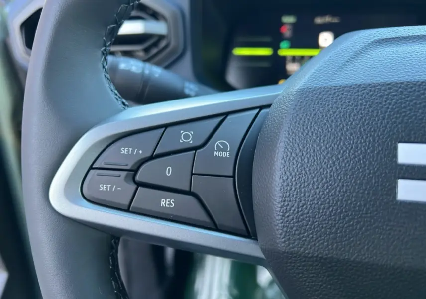 Gros plan sur les commandes au volant du Dacia Duster 2025, version Mild Hybrid 130 4x4 Expression, avec volant cuir noir.