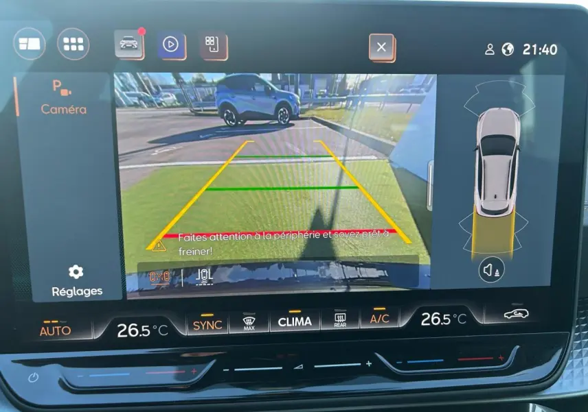 Vue de l'écran caméra de recul du CUPRA Formentor blanc neige avec guidage de stationnement et alertes visibles.