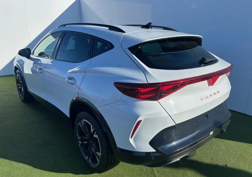 Vue 3/4 arrière droite du CUPRA Formentor blanc neige avec bandeau lumineux arrière et jantes alliage noires.