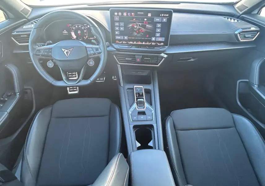 Vue intérieure avant du CUPRA Formentor blanc neige 2025, avec tableau de bord digital et volant multifonction cuir noir.