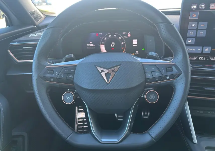 Vue rapprochée du volant cuir perforé noir avec logo CUPRA et tableau de bord digital du Formentor 2025.