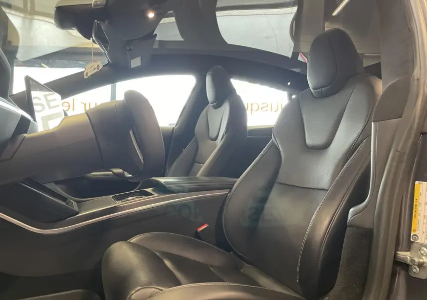 Vue intérieure côté droit du Tesla Model S Plaid 2023, sièges en cuir noir avec finitions en fibre de carbone.