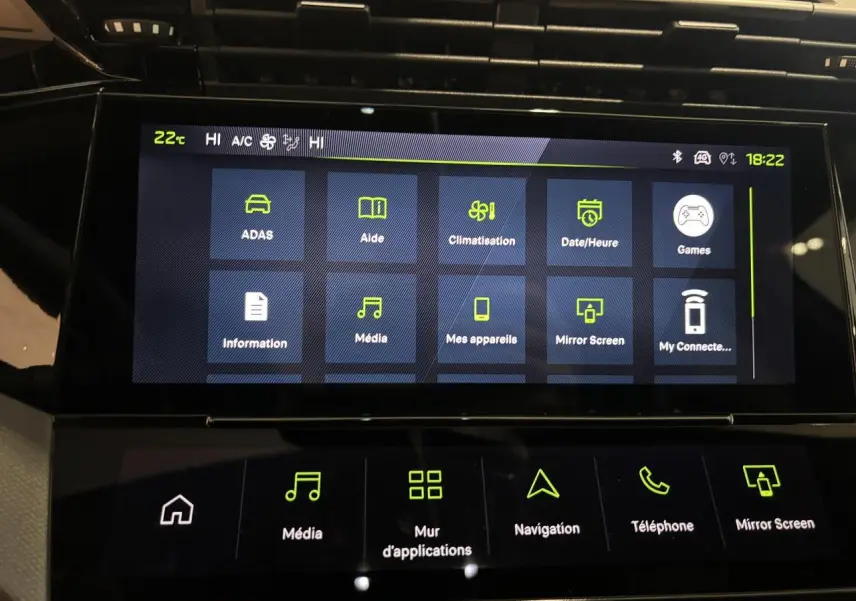 Écran tactile central de la Peugeot 308 hybride blanc Okenite, affichant le menu des applications et réglages multimédia.