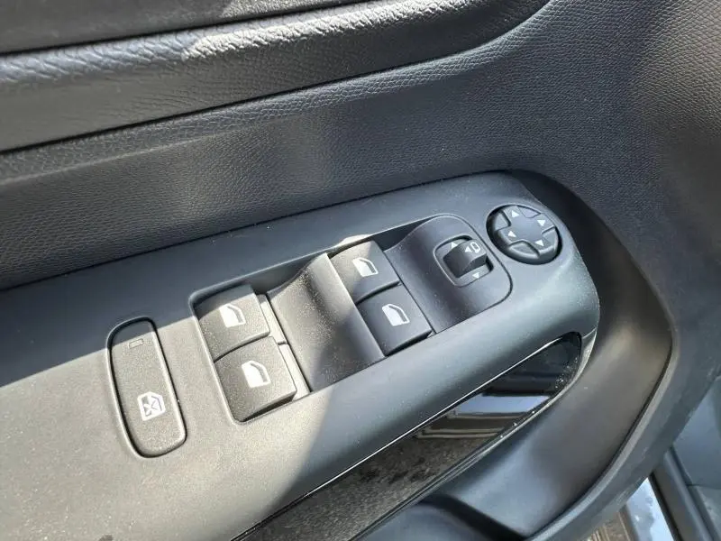 Gros plan sur les commandes des vitres électriques et rétroviseurs côté gauche d’un Citroën C5 Aircross 2025 gris Platinium.