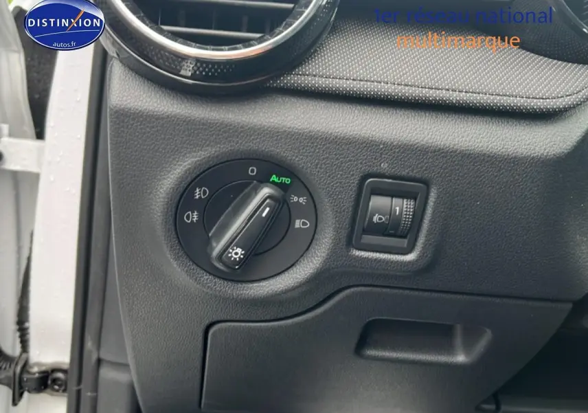 Détail du tableau de bord côté gauche de la Skoda Fabia blanche 2025 avec commande des phares et réglage d’intensité.