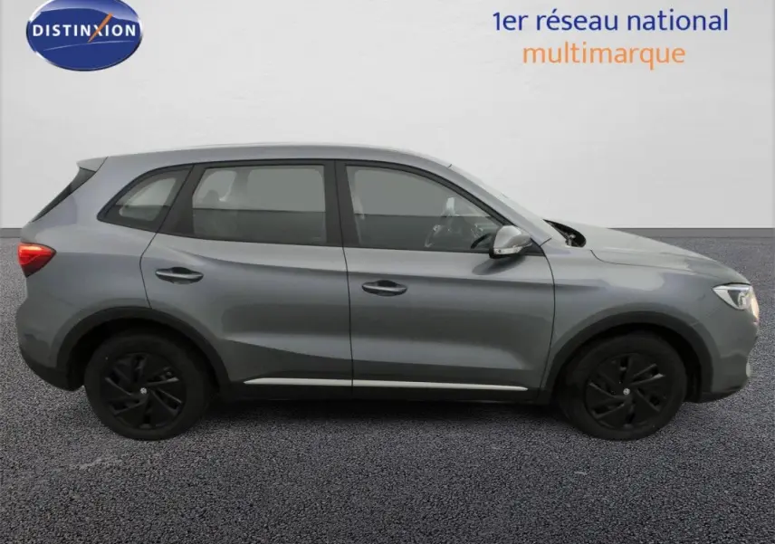 Vue latérale droite d’un SUV MG ZS 1.5L Hybrid+ 2026 en gris Hampstead avec jantes noires et vitres teintées.