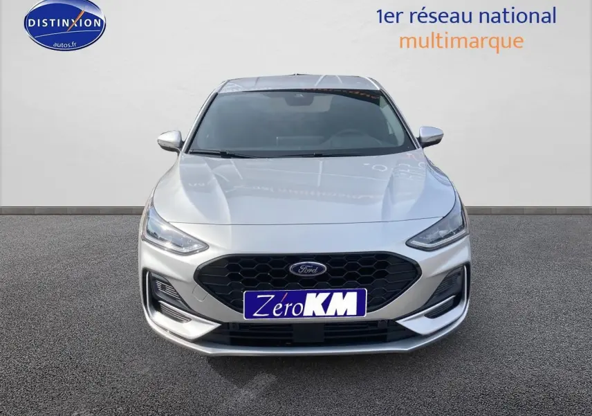 Vue frontale d'une Ford Focus gris clair avec calandre noire et feux LED modernes sur fond neutre.