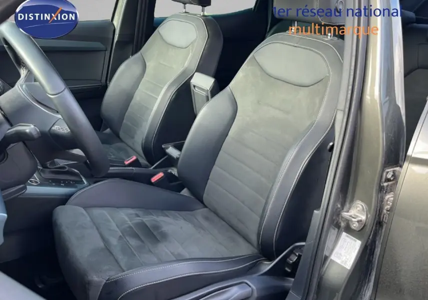 Vue intérieure côté conducteur du SEAT Arona 2025 gris falaise, sièges en cuir noir et alcantara gris.