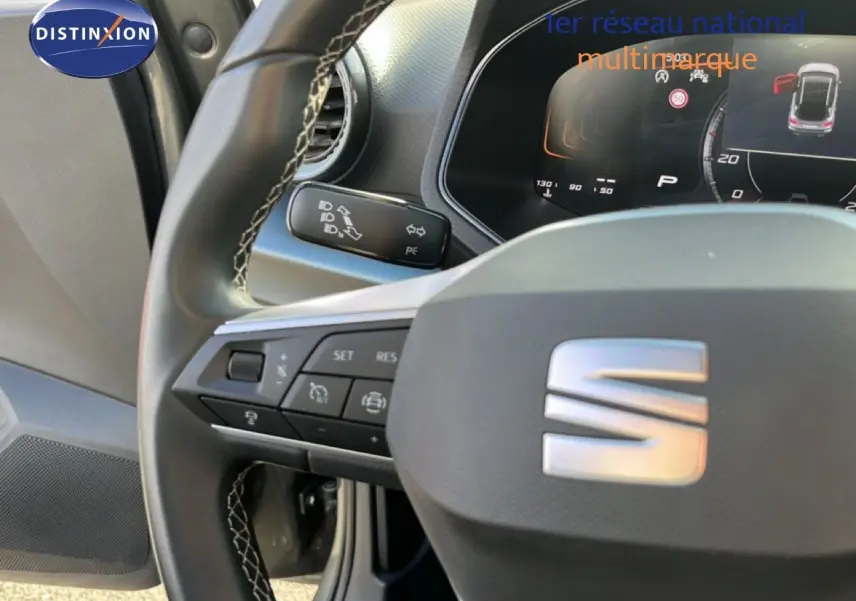 Vue rapprochée du volant et du tableau de bord numérique du SEAT Arona 2025, intérieur noir avec commandes au volant.