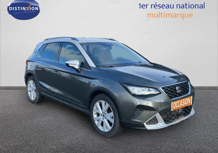 SEAT Arona gris falaise métal avec toit blanc, vue 3/4 avant droit, calandre et jantes visibles, plaque occasion orange.