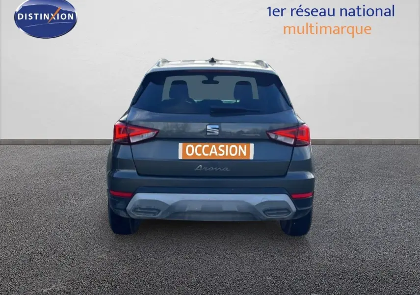 Vue arrière d'un SEAT Arona gris falaise métal avec toit blanc, affichant la plaque "OCCASION" sur fond neutre.