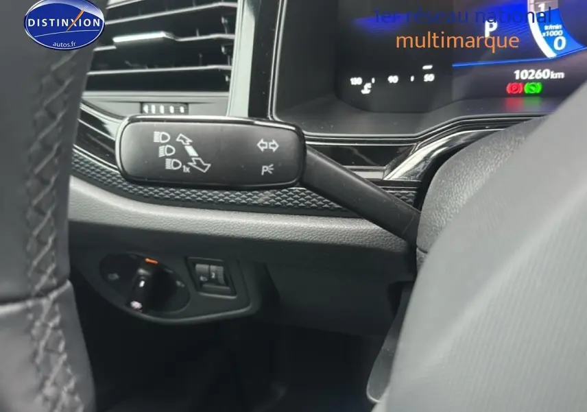 Détail intérieur du commodo gauche et tableau de bord numérique d'une Volkswagen Polo noire intense nacre 2025.