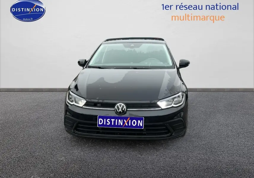 Vue frontale d'une Volkswagen Polo noire intense nacrée 2025 avec calandre épurée et phares LED allumés.