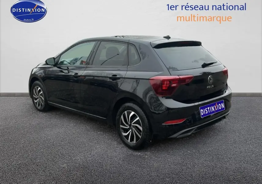 Volkswagen Polo noir intense nacré vue 3/4 arrière côté gauche sur sol gris devant mur blanc.