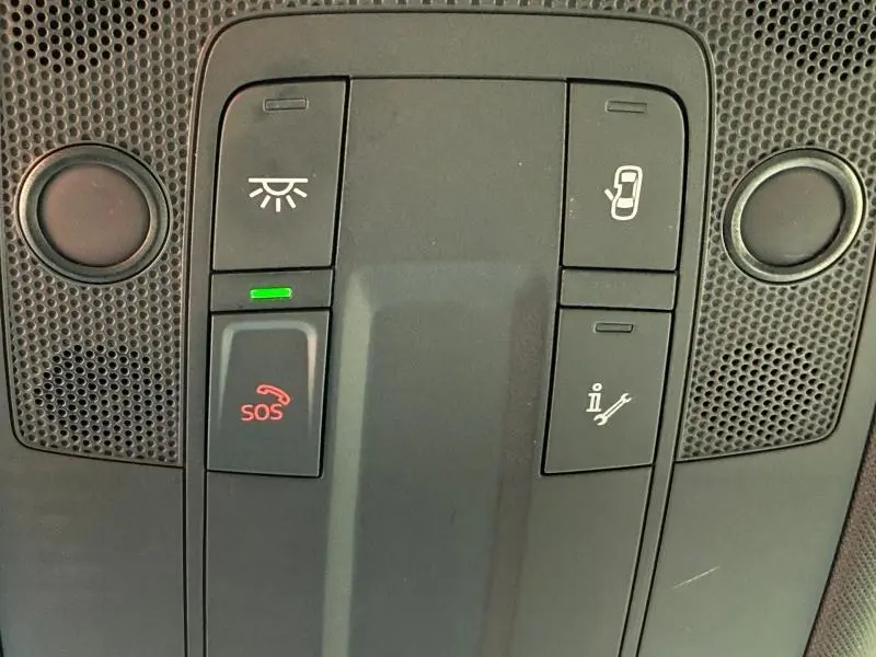 Gros plan sur la console de toit de l'Audi Q2 35 TDI S line 2025, avec boutons SOS, éclairage et assistance, finition noire.