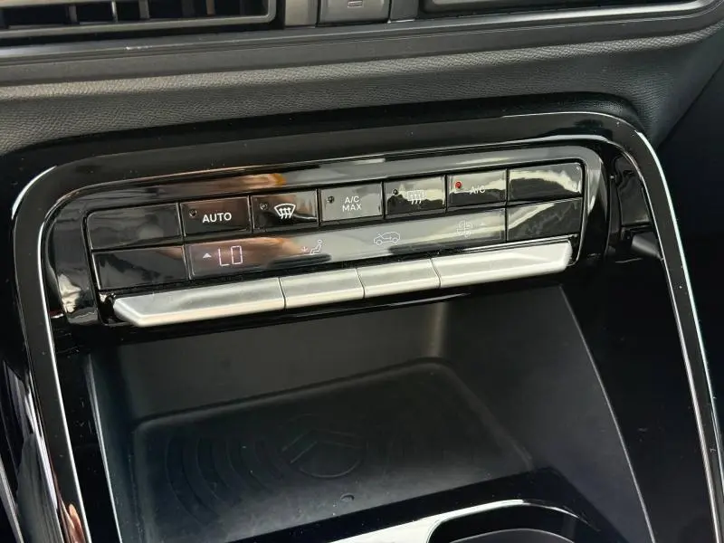 Gros plan sur la console centrale noire brillante de la Citroën C3 1.2 Turbo 2025 avec commandes climatisation automatique.