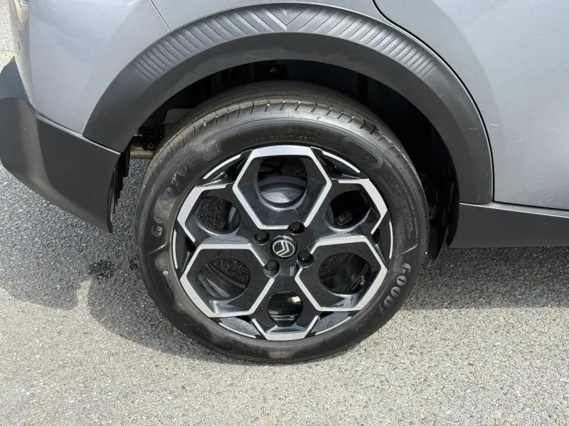Gros plan sur la roue avant droite d'une Citroën C3 gris Mercury avec jante alu au design hexagonal.