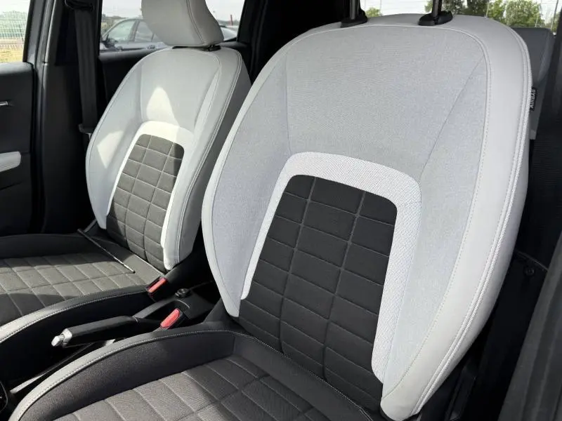 Gros plan sur les sièges avant bicolores gris clair et noir de la Citroën C3 2025, finition tissu City.