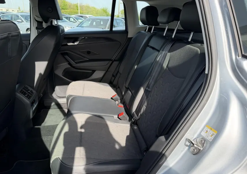 Vue intérieure côté droit des sièges arrière gris et noirs du Volkswagen Tiguan 2025 avec porte ouverte.
