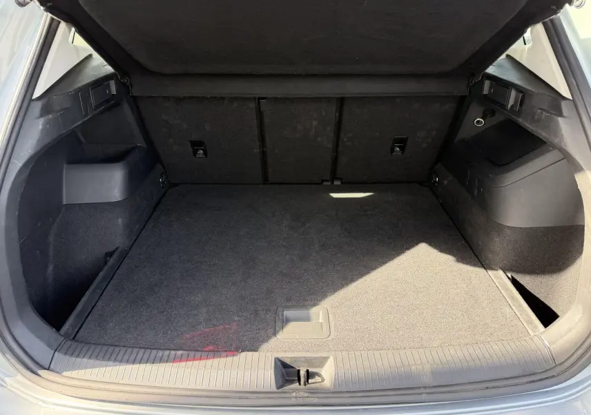 Coffre ouvert du Volkswagen Tiguan gris 2025, vue intérieure montrant un espace de chargement propre et spacieux.