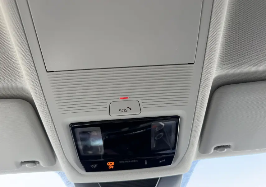 Vue intérieure du plafonnier gris clair du Volkswagen Tiguan 2025 avec bouton SOS et éclairage intégré.