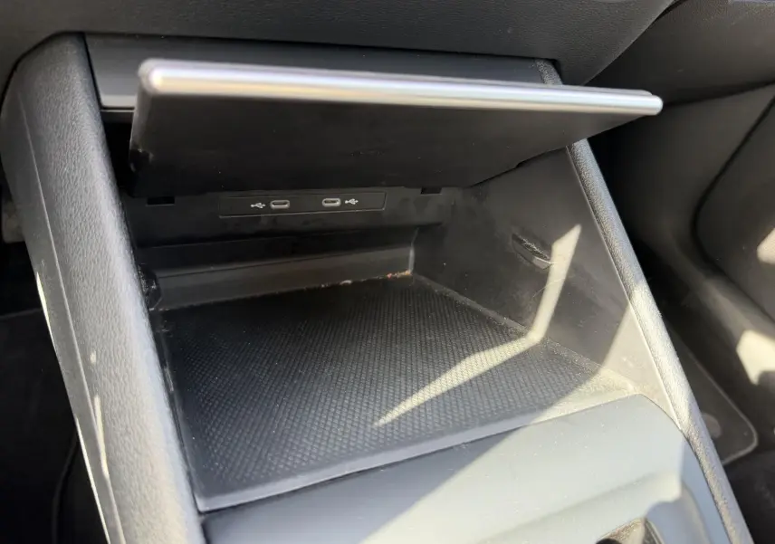 Rangement central ouvert avec deux ports USB-C visibles dans l'habitacle noir du Volkswagen Tiguan gris.