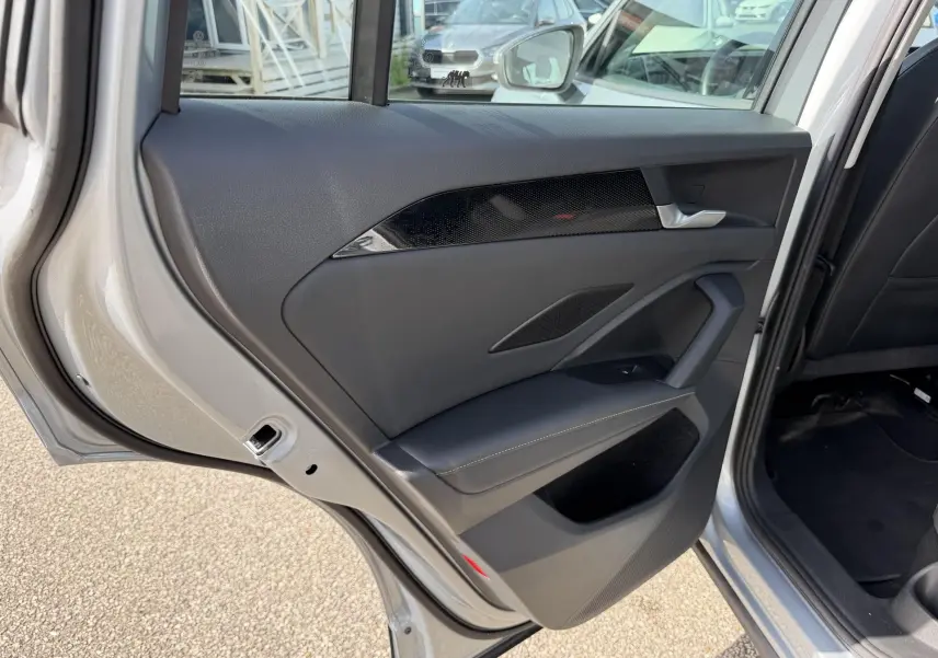 Vue rapprochée de la porte arrière gauche grise du Volkswagen Tiguan 2025, avec garniture noire et insert décoratif brillant.