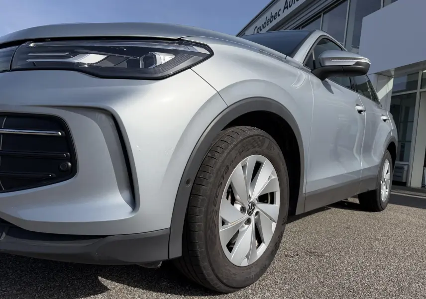 Vue 3/4 avant droit du Volkswagen Tiguan gris, mettant en valeur le projecteur LED et la jante alliage 17 pouces.