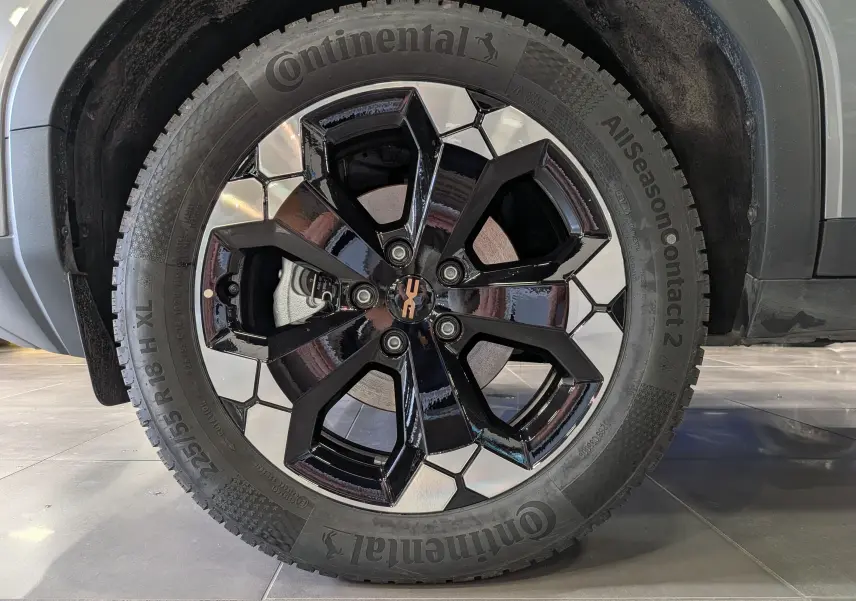Gros plan sur la roue avant droite du Dacia Bigster gris schiste, jante bi-ton noire et argentée au design moderne.