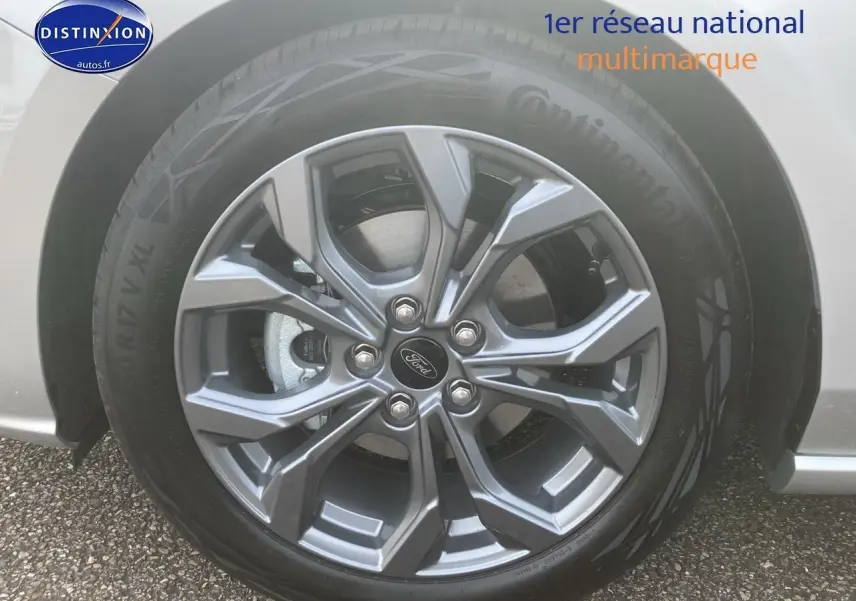 Gros plan sur la jante alu 17 pouces gris foncé d'une Ford Focus gris clair 2025 côté gauche.