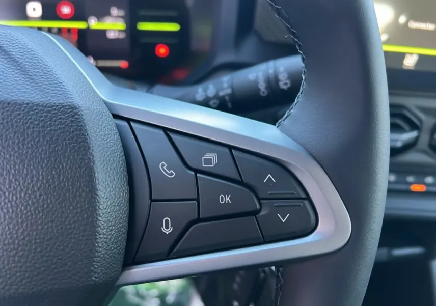 Gros plan sur les commandes au volant du Dacia Duster 2025, version Mild Hybrid 130 4x4 Expression, avec boutons multifonctions.