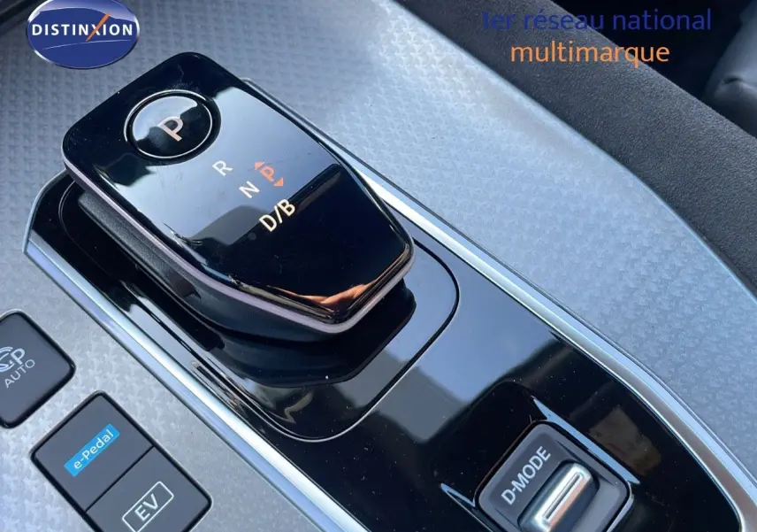 Gros plan sur la commande de boîte automatique noire du Nissan Qashqai 2025 hybride, avec bouton e-Pedal et mode D.