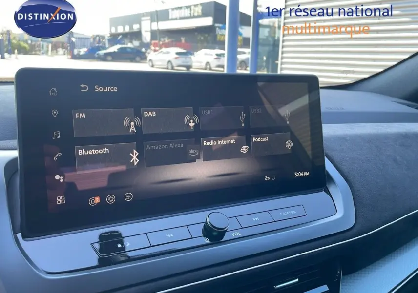 Tablette tactile centrale affichant les sources audio dans l'habitacle du Nissan Qashqai gris céramique 2025, vue de face.