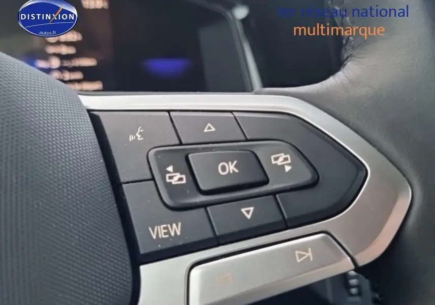 Gros plan sur les commandes multifonctions noires et argent du volant cuir d'une Volkswagen Polo 2025 noir intense nacré.