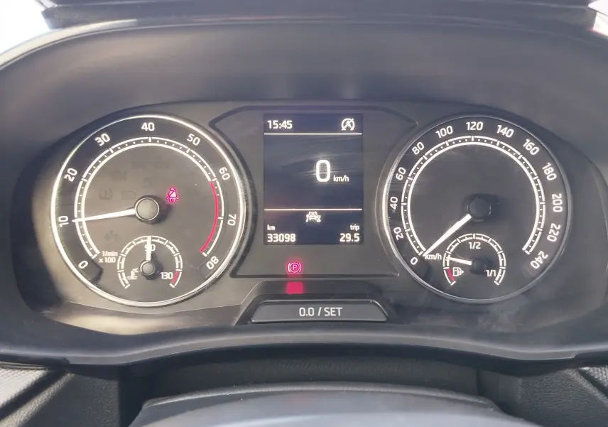 Vue rapprochée du tableau de bord de la Skoda Fabia blanche, affichant vitesse à 0 km/h et compteurs analogiques.