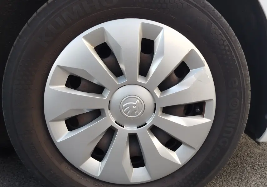 Gros plan sur la roue avant droite d’une Skoda Fabia blanche, avec enjoliveur argenté au design moderne.