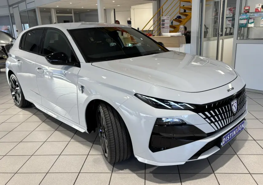 PEUGEOT 308 hybride blanche vue 3/4 avant droit en showroom avec calandre noire distinctive et jantes bi-ton.