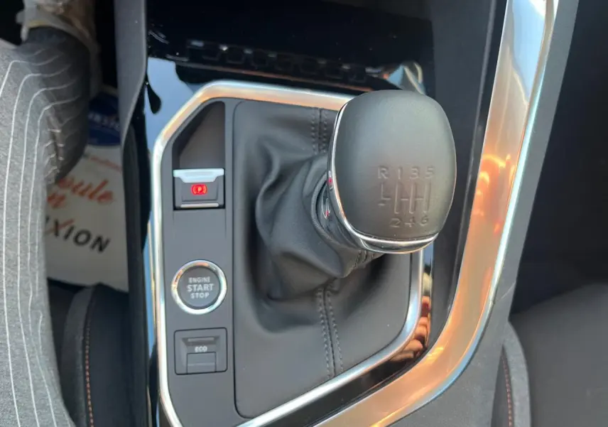 Gros plan sur le levier de vitesses manuel et les boutons de commande du Peugeot 3008 gris Artense, intérieur noir.