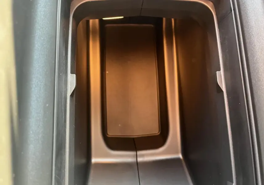 Gros plan sur le rangement central intérieur du Peugeot 3008 gris Artense, éclairé par une lumière ambre douce.
