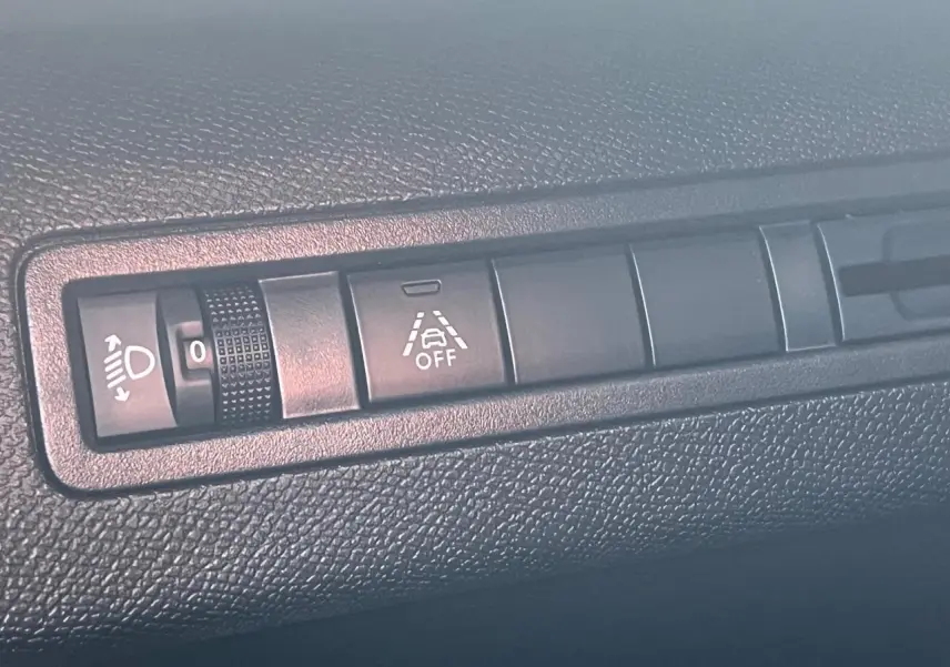 Gros plan sur les commandes de réglage des phares et de l'alerte de franchissement de ligne dans un Peugeot 3008 2023.