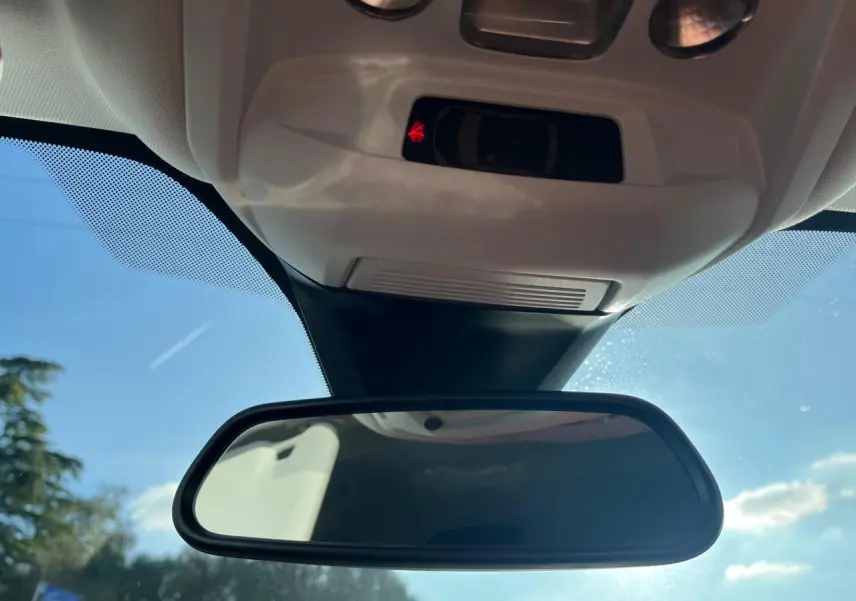 Rétroviseur intérieur d’un Peugeot 3008 gris Artense 2023, avec capteurs et ciel bleu en arrière-plan.