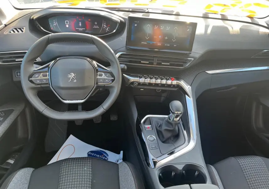 Vue intérieure du poste de conduite du Peugeot 3008 gris Artense 2023, volant compact et écran tactile central 10 pouces.