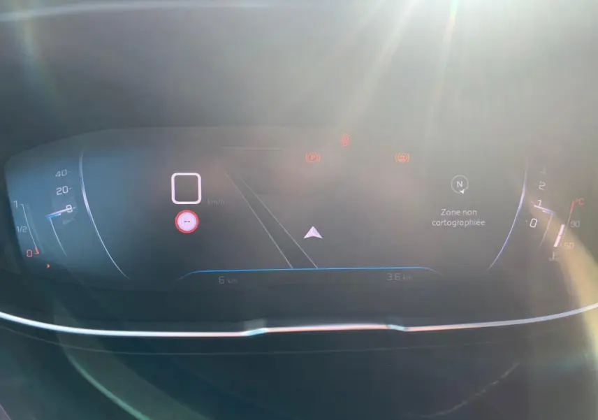 Tableau de bord numérique du Peugeot 3008 2023, affichant la navigation et les indicateurs sous un fort éclairage solaire.