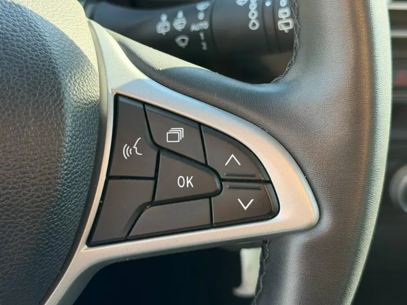 Gros plan sur les commandes multifonctions à droite du volant en cuir noir du Dacia Jogger gris Schiste métallisé 2025.