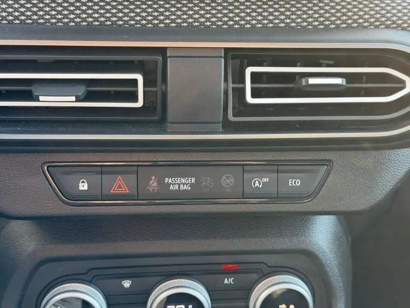Détail du tableau de bord du Dacia Jogger 2025 montrant les aérateurs et les boutons de sécurité et mode ECO.