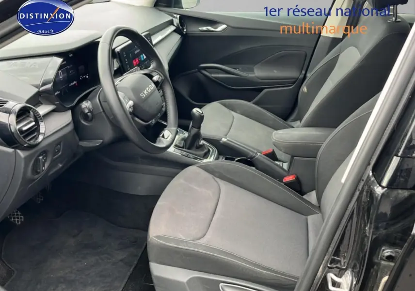 Intérieur avant noir de la Skoda Fabia 2025, vue côté conducteur avec volant cuir et console centrale manuelle.