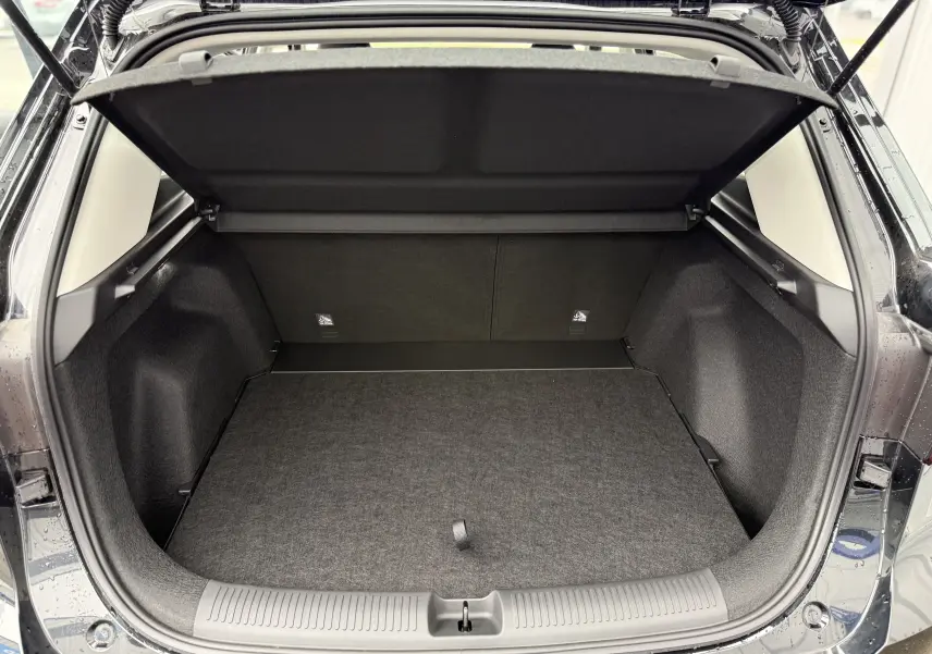 Coffre ouvert vu de l'arrière d'un MG ZS 1.5L Hybrid+ 2026 en Pebble Black Metal, espace de chargement vide et propre.