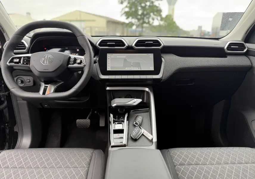 Vue intérieure avant du MG ZS 2026 avec tableau de bord noir, écran tactile central et volant multifonction.