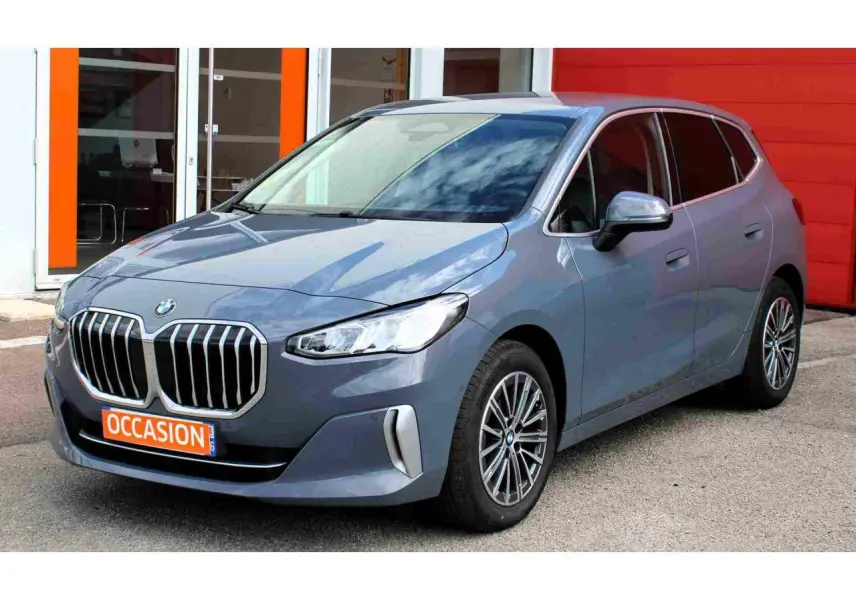 BMW Série 2 Active Tourer gris vue 3/4 avant droit avec calandre chromée et jantes alliage 17 pouces.