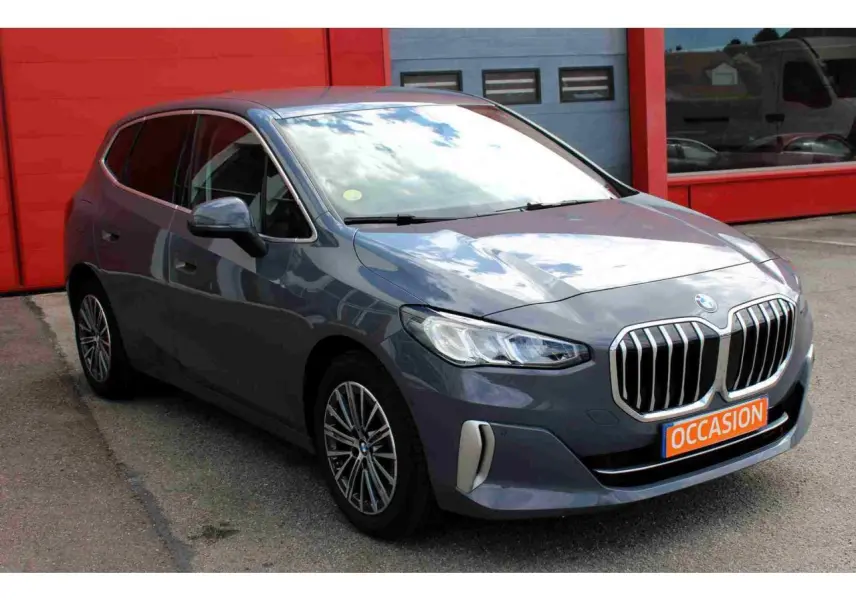 BMW Série 2 Active Tourer gris vue 3/4 avant avec calandre imposante et jantes alliage 17 pouces bicolores.